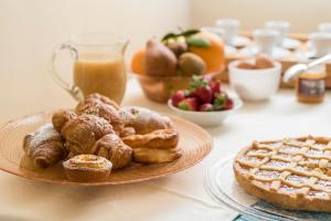 un tavolo con un piatto di prodotti da forno e un bicchiere di succo d'arancia di Fattoria Pian Di Rocca a Castiglione della Pescaia
