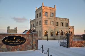 un edificio con una señal delante de él en Chateau Royal Hotel, en Berezovka