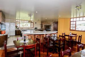 a restaurant with tables and chairs and a kitchen at Hosteria Loma Larga Cayambe in Cayambe