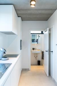 Una cocina con gabinetes blancos y un fregadero. en BeHome Dilbeek, en Dilbeek