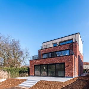 Un edificio de ladrillo rojo con muchas ventanas. en BeHome Dilbeek, en Dilbeek
