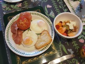 a plate of eggs and a bowl of vegetables on a table at Ohuka Place Homestay in Whitianga