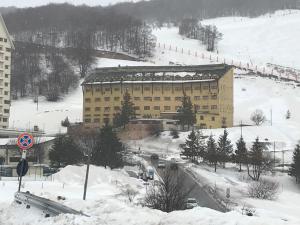 a large building in the snow next to a road at Villa Aremogna in Roccaraso