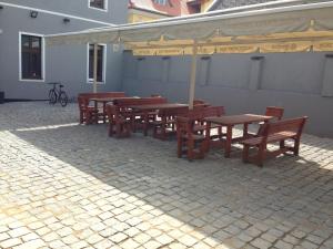 a group of wooden tables and chairs under an umbrella at Restaurace U Kostela in Mariánské Radčice