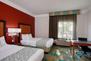 a hotel room with two beds and a desk at La Quinta by Wyndham Winston-Salem in Winston-Salem