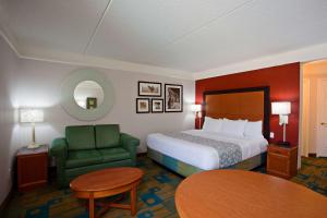 um quarto de hotel com uma cama e uma cadeira verde em La Quinta by Wyndham Winston-Salem em Winston-Salem