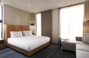 メルボルンにあるHyatt Place Melbourne Essendon Fieldsのベッドとソファのあるホテルの部屋