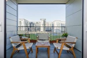 balcone con sedie, tavoli e vista sugli edifici di Appartamento Gassman - Holiday Apartment in Milano a Milano