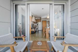 un balcone con 2 sedie e un tavolo e un soggiorno di Appartamento Gassman - Holiday Apartment in Milano a Milano