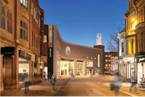 a group of people walking down a street with buildings at The Percy's Luxury in Oxford