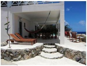 a patio with a bench and chairs on a house at Dolphin Hearthouse in Lagun