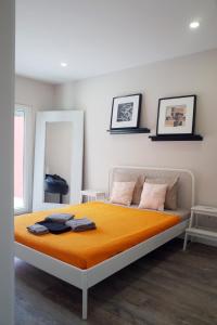 コスタ・ダ・カパリカにあるLisbon Beach Apartments 7のベッドルーム1室(オレンジ色の毛布付きのベッド1台付)