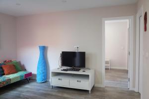 a living room with a tv on a white cabinet at Lisbon Beach Apartments 7 in Costa da Caparica