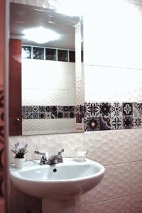 y baño con lavabo y espejo. en Posada La Merced, en Arequipa
