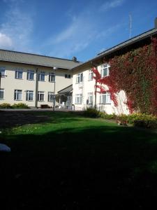 un edificio con una pared cubierta de hiedra junto a un patio en Yömyssy Apartments, en Kerimäki