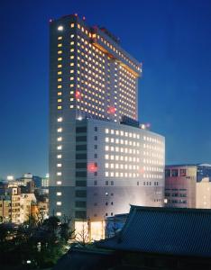 un edificio alto con luces encendidas en una ciudad en Dai-ichi Hotel Ryogoku, en Tokio