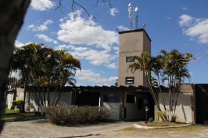 a building with palm trees in front of it at Motel Kokeluxe in Cachoeira Paulista