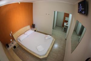 Dormitorio pequeño con cama y TV en Motel Kokeluxe en Cachoeira Paulista