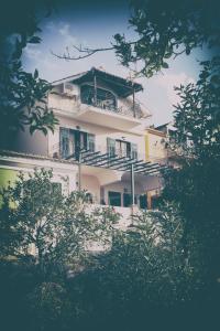 a white building with balconies on the side of it at Photographer's Apartments in Alikanas