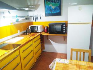 una cucina con bancone, forno a microonde e frigorifero di Casa junto a Itálica a Santiponce