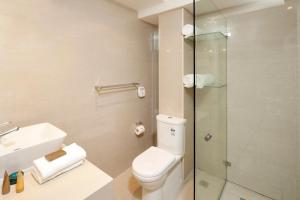 a bathroom with a toilet and a glass shower at Best Western Plus Hotel Stellar in Sydney