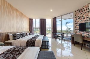 una camera d'albergo con due letti e una TV a schermo piatto di Kenting 213 Homestay a Città Vecchia di Hengchun