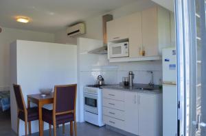 a kitchen with white appliances and a table and chairs at Montevideo al oeste, algo distinto... in Colón