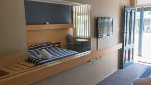 a mirror in a room with a bed and a tv at Windsor Motel in Windsor