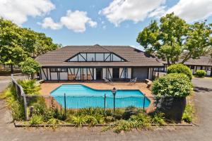 un'immagine di una casa con piscina di Oakwood Manor Motor Lodge ad Auckland
