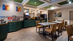 un restaurante con armarios verdes, mesa y sillas en Best Western John Muir Inn, en Martinez