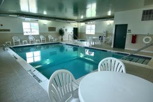 una gran piscina con mesa y sillas en un edificio en Country Inn & Suites by Radisson, Chambersburg, PA en Chambersburg