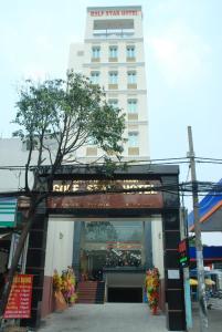 uma frente de loja com um edifício ao fundo em Golf Star Hotel em Ho Chi Minh