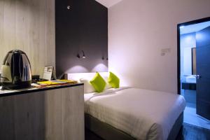 Manhattan Hotel Ipoh في ايبوه: غرفة نوم بسرير ومكتب مع خوذة