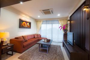 a living room with a couch and a table at Huernnana Boutique Hotel in Phrae