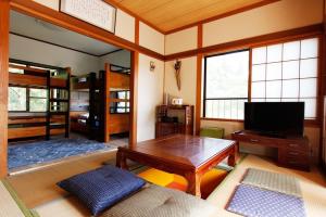 uma sala de estar com uma mesa e uma televisão em Midorian em Nikko