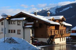 a building covered in snow with a car parked in front at Tischlerwirt in Uttendorf