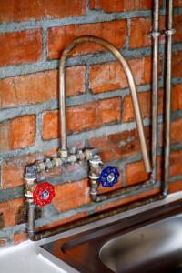 a kitchen sink attached to a brick wall at Rustic Retreat Apartment in Durbanville in Durbanville