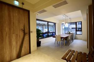 a dining room with a table and a wooden door at Sakagami Hotel in Tainan