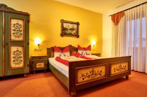 1 dormitorio con 1 cama grande con almohadas rojas en Komfort- & Wellnesspension Rehwinkel, en Bodenmais