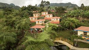 eine Gruppe von Häusern auf einem Hügel mit einer Brücke in der Unterkunft La Divina Providencia in Jardin