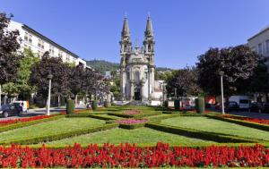 un giardino con fiori di fronte a un edificio di Casa Porta Nova AL a Guimarães