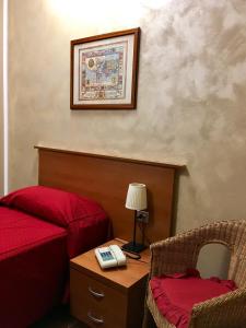 1 dormitorio con 1 cama y 1 mesa con teléfono en Hotel Forum, en Rozzano