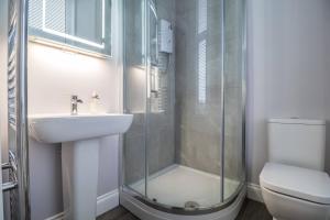 a bathroom with a shower and a sink and a toilet at West Highland Apartments Milngavie - The Lomond in Milngavie +14 photos