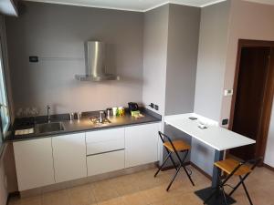 uma cozinha com um balcão, um lavatório e uma mesa em Airport Orio Studio em Bérgamo