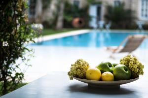 a bowl of fruit on a table next to a pool at Manastir Alacati Hotel in Alacati
