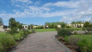 a brick walkway in a park with a field and houses at Sleepwell in East London