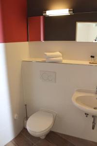 a bathroom with a white toilet and a sink at Ferienappartments Schleswig in Schleswig