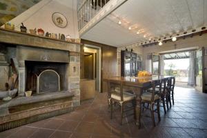 a dining room with a table and a fireplace at Villa Al Mennucci in Ruota