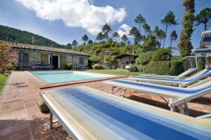 a pool with two lounge chairs and a house at Villa Al Mennucci in Ruota