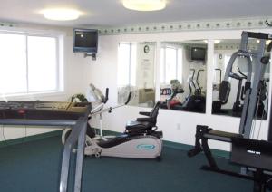 Habitación con gimnasio con cinta de correr y espejo en Highland Lake Resort en Bridgton